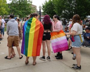 A crowd gathered in Goderich’s Courthouse Square for a Pride festival. Several young people in front are wrapped in Pride flags.