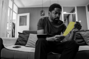 A frustrated man reviews a receipt.